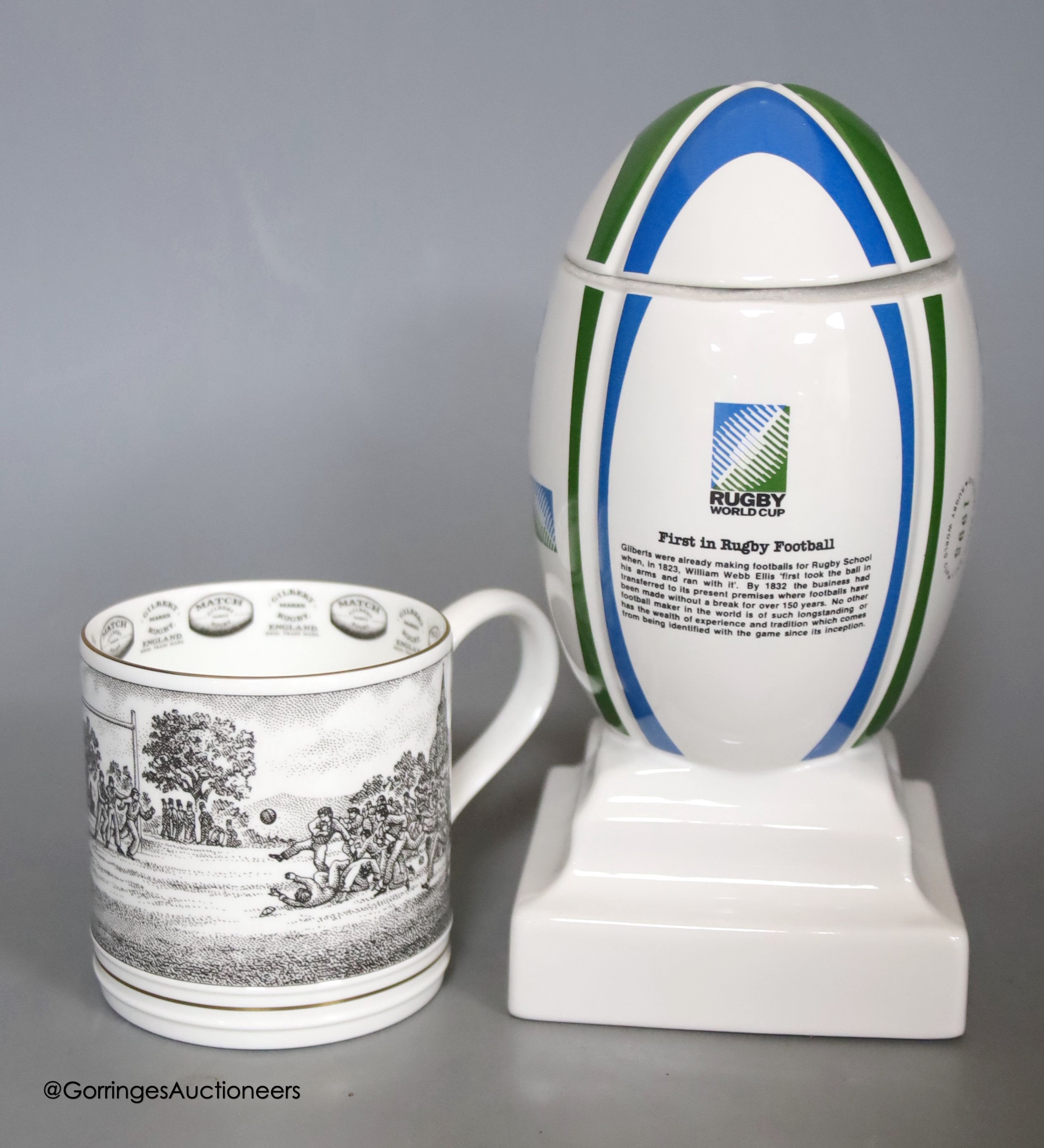 A Wade porcelain Gilbert Rugby ball box and cover, together with two Grand Slams 1991 and 1992 ties, and a Wedgwood Gilbert Rugby mug produced specially for The James Gilbert Rugby Football Collection, limited edition of